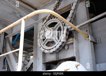 A complex gear mechanism showcases precision engineering in a bustling factory. Stock Photo