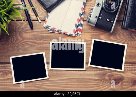 Blank photo frames, camera and supplies on table Stock Photo