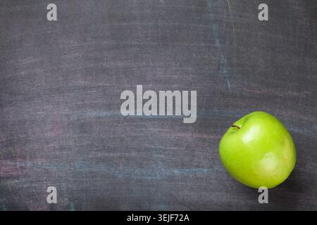 Green apple on blackboard or chalkboard background Stock Photo