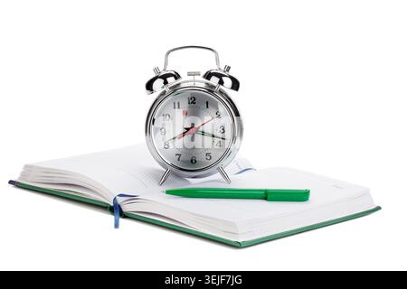 Alarm clock and pen on notepad Stock Photo