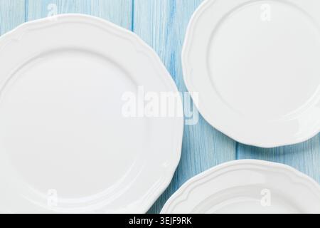 Empty plates over wooden table Stock Photo
