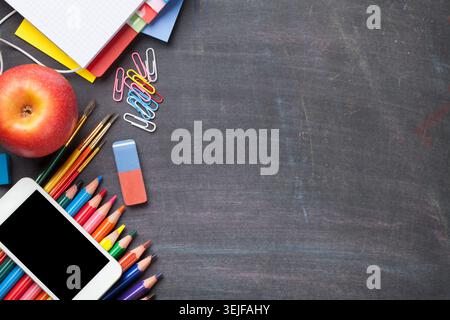 School supplies on blackboard background Stock Photo