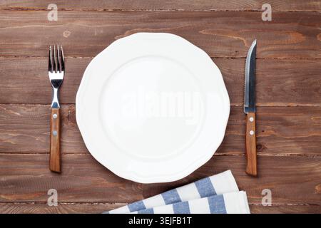 Empty plate and silverware over wooden table Stock Photo