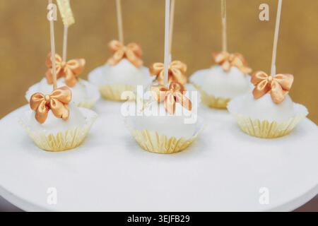Delicate cake pops sit on a white plate Stock Photo