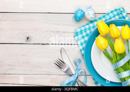 Easter background with yellow tulips and colorful eggs Stock Photo