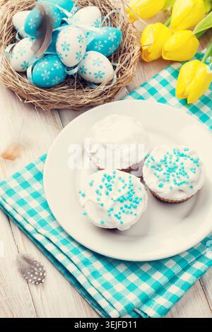 Easter with yellow tulips, colorful eggs and traditional cakes Stock Photo