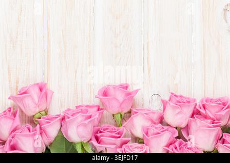 Valentines day background with pink roses over wooden table Stock Photo