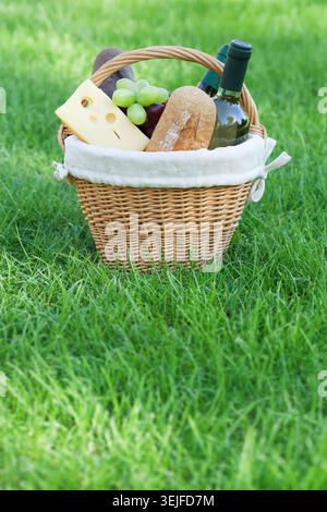 Outdoor picnic basket with wine on lawn Stock Photo