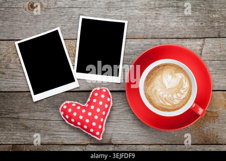 Two photo frames over wooden background with red coffee cup Stock Photo