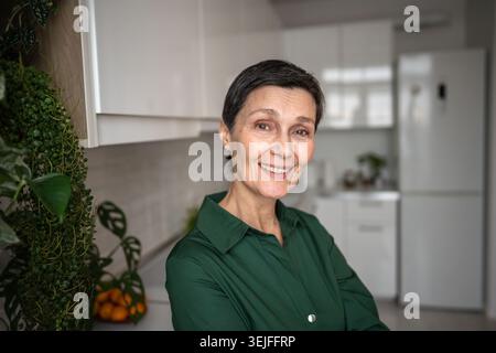 Joyful mature woman smiling happily looking at camera at home, natural self. Self acceptance Stock Photo