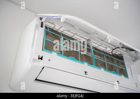 Closeup of dirty dust air conditioner filter on wall. Home air conditioner maintenance Stock Photo