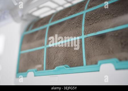 Closeup of dirty dust air conditioner filter on wall. Home air conditioner maintenance Stock Photo