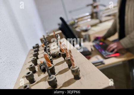 Operator Entering Coordinates on Computer for CNC Machine to Precisely Cut Wooden Pieces Stock Photo