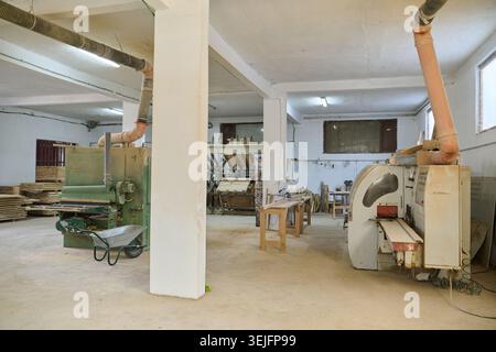 An interior view of a wood processing facility showcasing CNC cutting machines and various wood processing equipment in action. Stock Photo