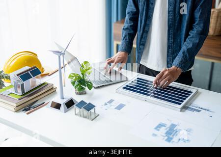 Businessman and Engineers Working on Solar Panels Project for Green Energy Accumulation in Eco-Friendly Office Stock Photo
