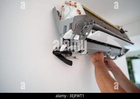 Damaged insulation on copper pipe of indoor air conditioner unit causing water leakage down wall Stock Photo