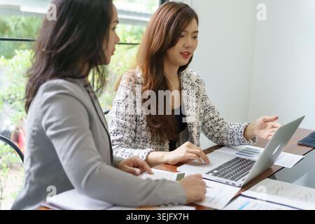Businesswoman Accountant analyzing investment charts Invoice and pressing calculator buttons over documents. Accounting Bookkeeper Clerk Bank Advisor Stock Photo