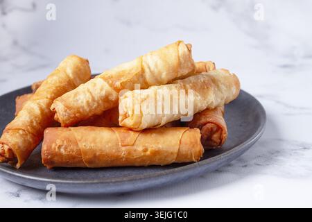 Fried spring rolls with cheese, on a plate, with cream sauce, no people, Stock Photo
