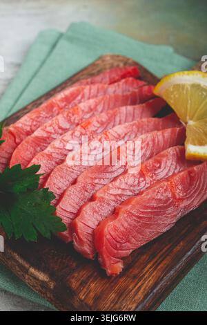 Chum salmon, cold smoked, sliced, on a cutting board, with lemon and parsley, top view, close-up, no people, Stock Photo
