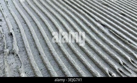 Close-up view of freshly applied cement with smooth, parallel grooves on a construction surface Stock Photo