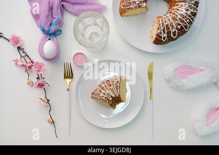 Top view Easter table setting, glazed Easter cake and candles on table decorated for Easter Stock Photo