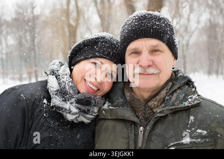 Elderly couple on walk in winter park Stock Photo