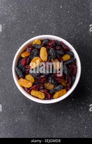 Dried cranberries, yellow and black sweet raisins as ingredients for a breakfast. Raisins and cranberries Stock Photo