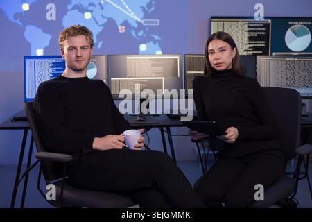 Cyber security team analyzing threats in a modern control room Stock Photo