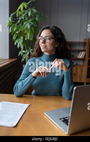 Smiling happy female employee at workplace looking in window and Stock Photo