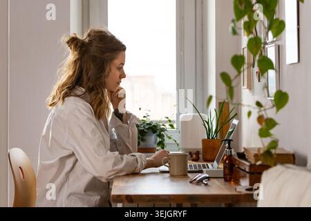 Young woman freelancer designer working on computer from home office Stock Photo