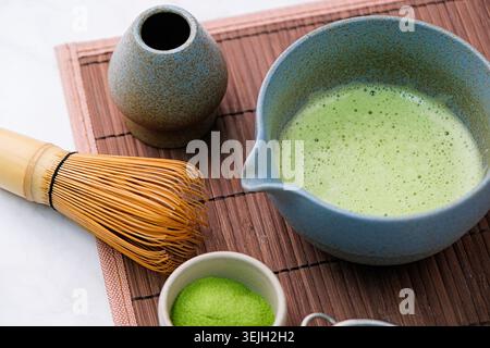 Traditional matcha kit, Bamboo whisk and beverage on bamboo mat in the kitchen Stock Photo