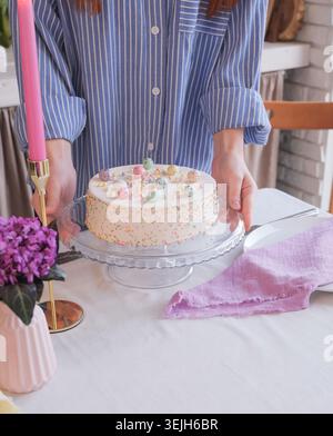 Caucasian woman serving table for Easter dinner Stock Photo
