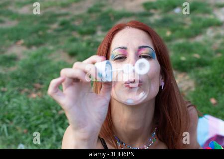 Queer person blowing bubbles celebrating pride and freedom Stock Photo