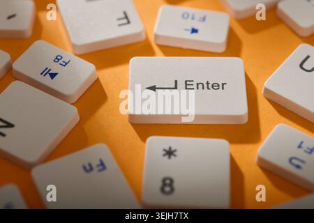Close-up of a collection of computer keyboard enter key on a orange table Stock Photo