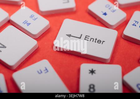 Close-up of a collection of computer keyboard enter key on a red table Stock Photo