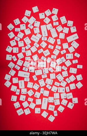 Close-up of a collection of computer keyboard keys from different laptops on a red table Stock Photo