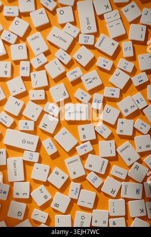 Close-up of a collection of computer keyboard keys from different laptops on a orange table Stock Photo