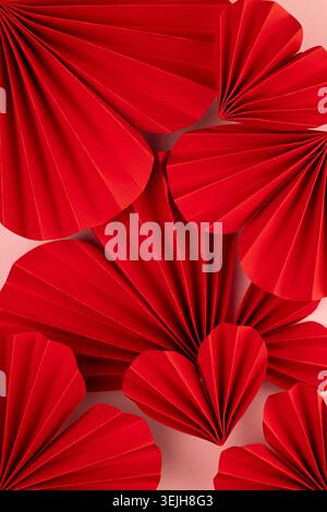 Valentines day background - red paper ribbed hearts different size as pattern, texture, top view, vertical. Stock Photo