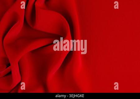 Deep red silk smooth wavy background with copy space. Stock Photo