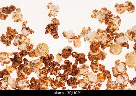 Popcorn with chocolate sauce on white background, top view. Stock Photo