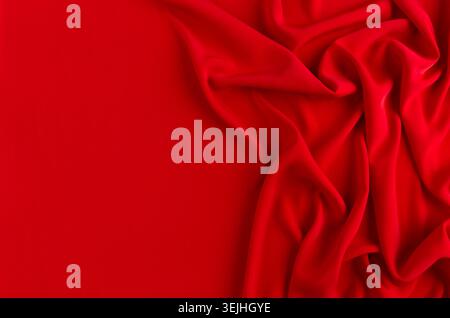 Deep red silk smooth wavy background with copy space. Stock Photo