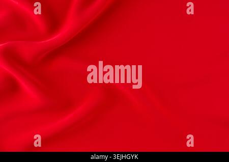 Deep red silk smooth wavy background with copy space. Stock Photo
