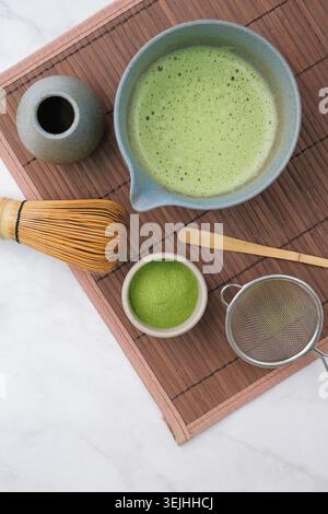 Traditional matcha kit, Bamboo whisk and beverage on bamboo mat in the kitchen Stock Photo