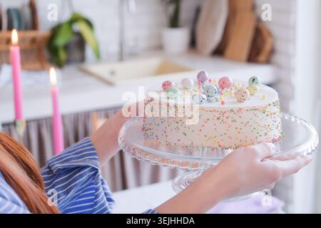 Woman serving table for Easter dinner and holding Easter cake Stock Photo