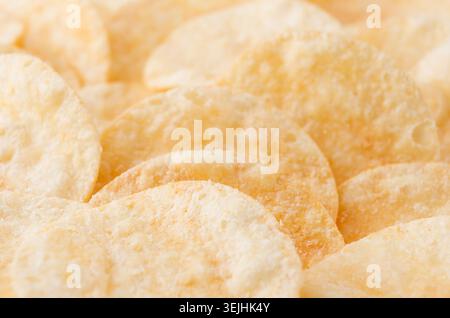 Crunchy potato chips with spices as background, closeup, top view. Stock Photo
