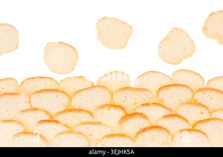 Ruddy croutons of white dry bread as frame isolated on white background, closeup. Snacks and fast food backdrop. Stock Photo