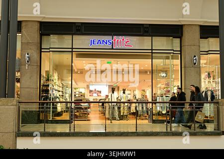 Glass front Jeans Fritz fashion store with mannequins, shoppers walking past inside mall Stock Photo
