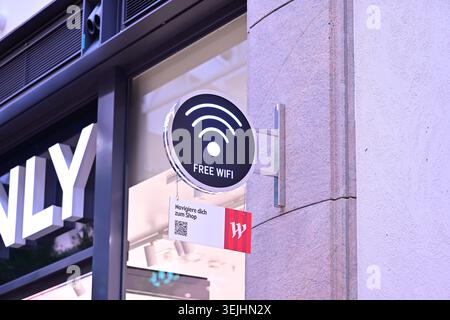Round free WiFi sign and QR code panel on stone wall outside Stock Photo
