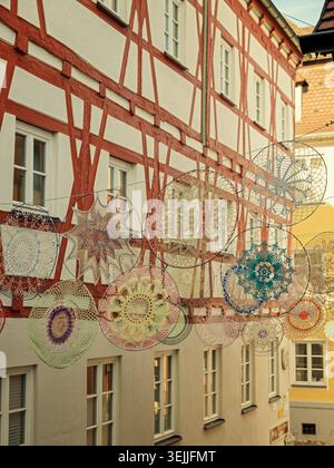 Harburg (Schwaben), Germany - 04.10.2022: Textile art installations suspended over a street in front of traditional German architecture Stock Photo