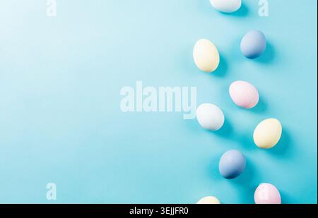Pastel colored easter eggs on blue background with copy space Stock Photo